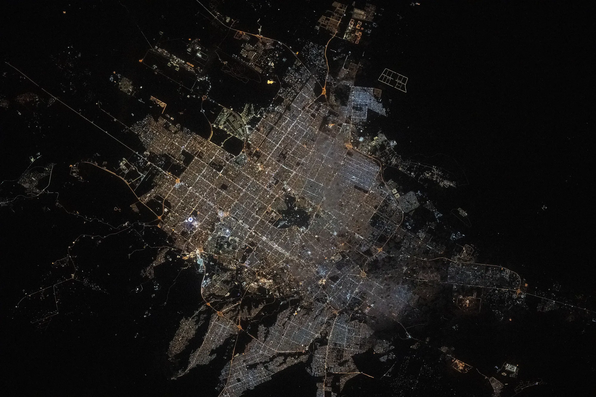 Riyadh seen from orbit at night: the street grid traced in orange and white lights