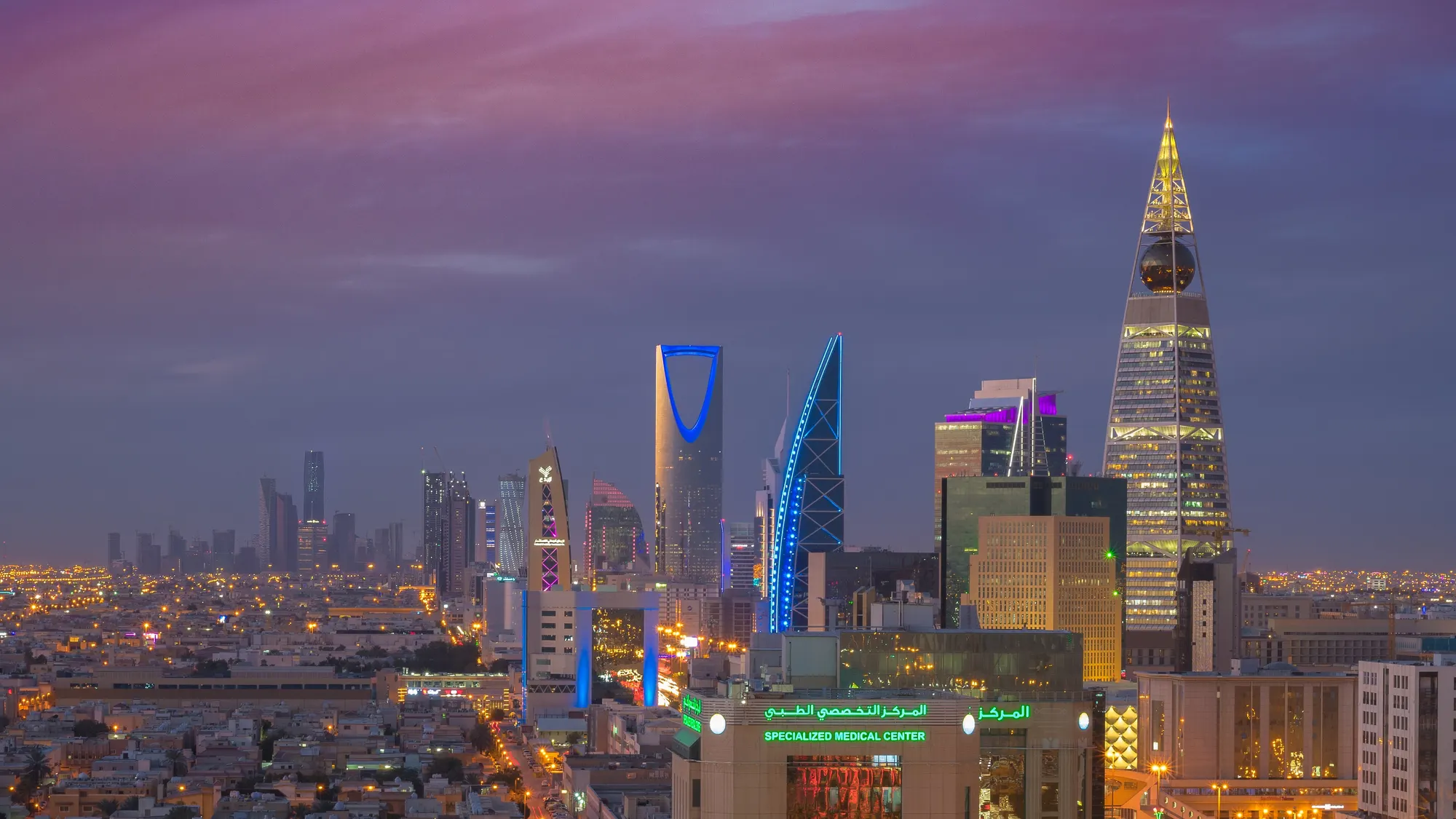 Riyadh at blue hour: the Kingdom Centre, Majdoul and Al Faisaliah towers lit above the city